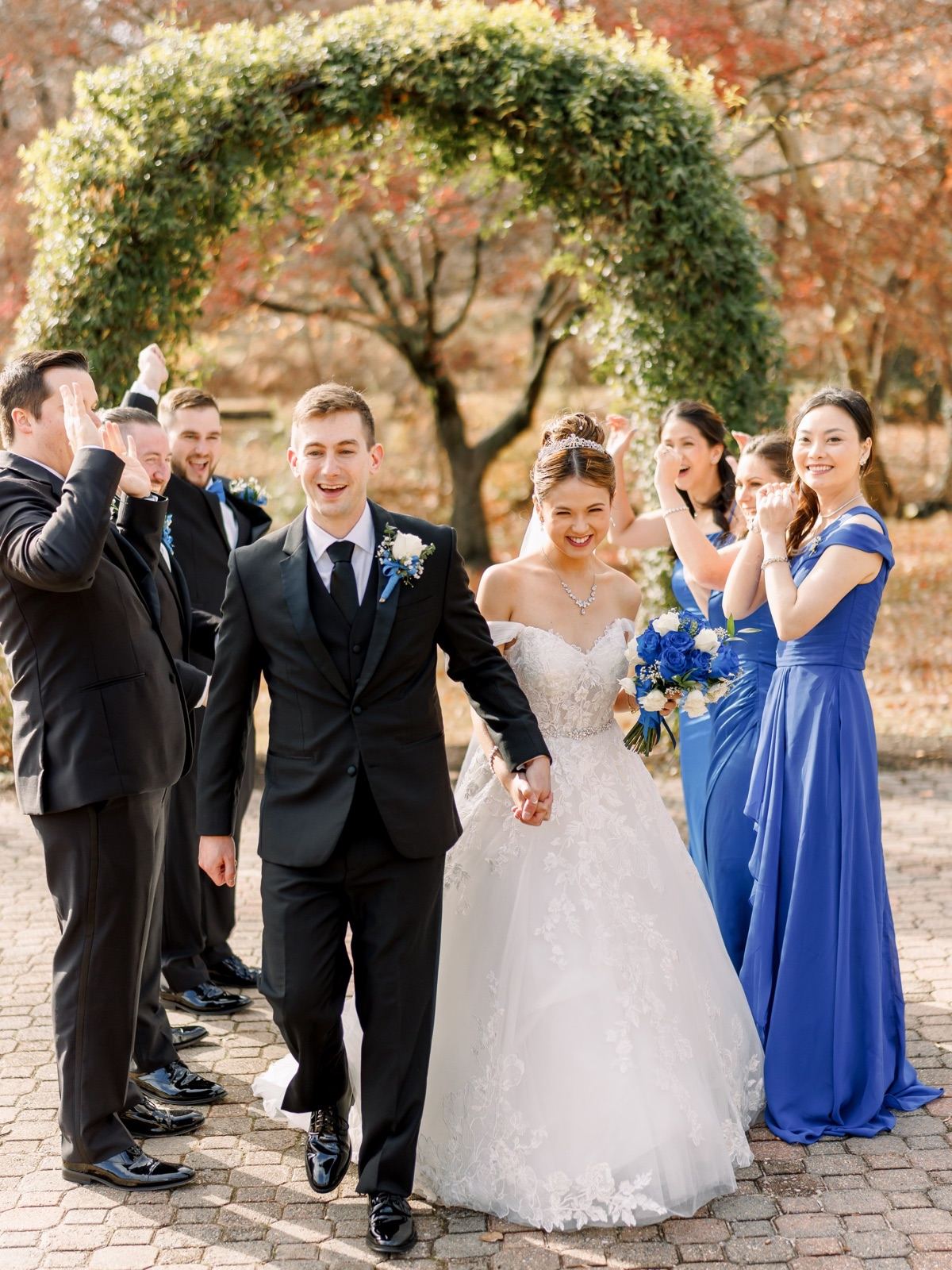 Bride and groom walking hand in hand past cheering bridesmaids and groomsmen after their ceremony — DMV wedding by Kevin Socola Films