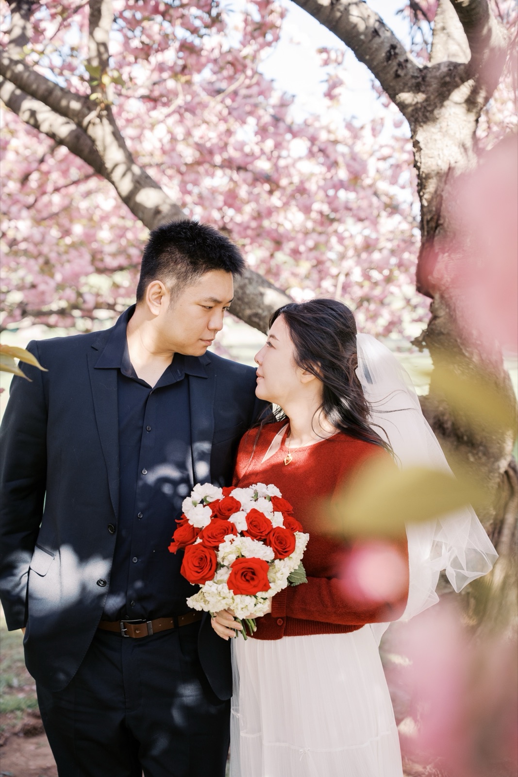 Couple with a red bouquet under the Kwanzan cherry blossoms in Washington, DC by Kevin Socola Films